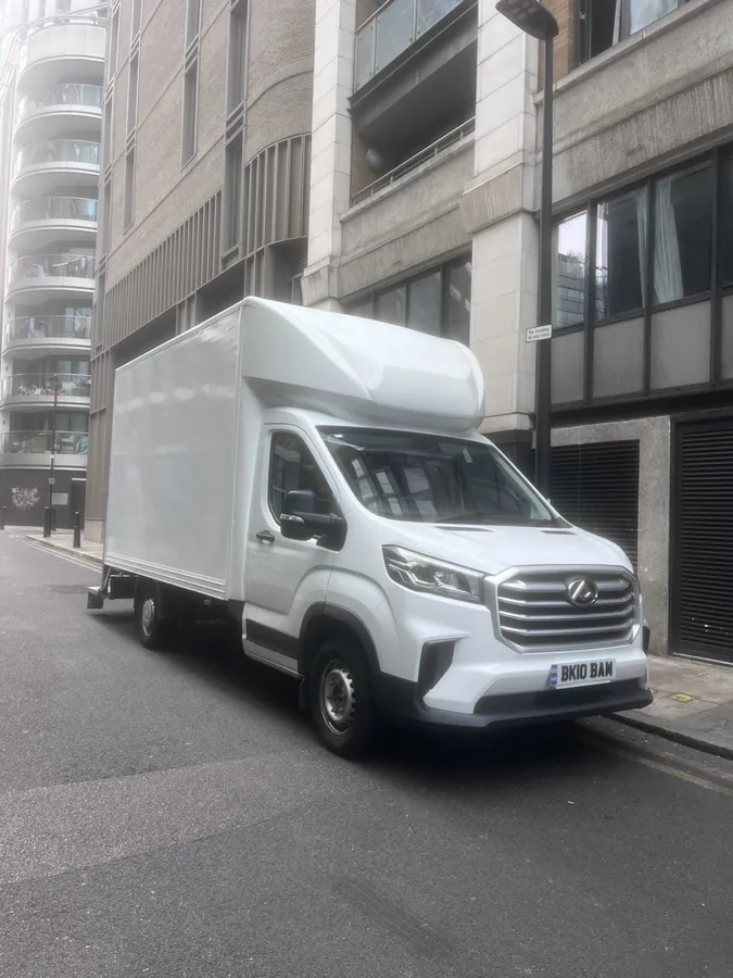 The Luton van parked on a city street between tall apartment blocks